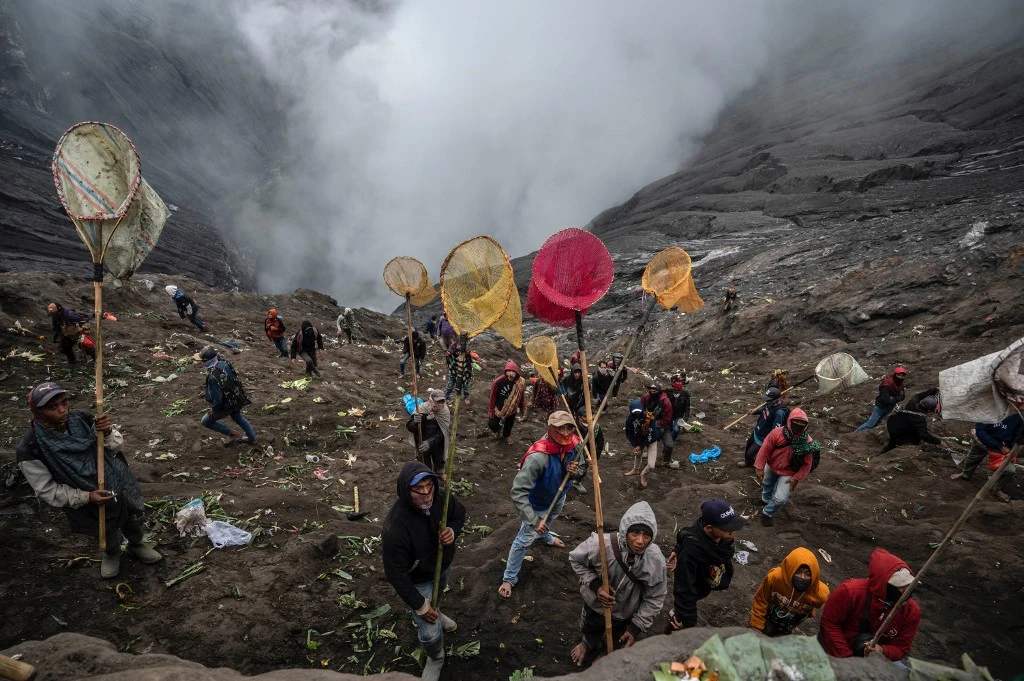 Adventurous trekker ascending the steep slopes of Mount Bromo, with panoramic views of the volcanic terrain