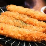 Tempura udang renyah berwarna keemasan, disajikan dengan saus tentsuyu