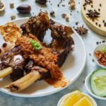 Seporsi Konro Bakar khas Makassar dengan iga sapi empuk yang dipanggang hingga kecokelatan, disajikan dengan sambal konro dan burasa